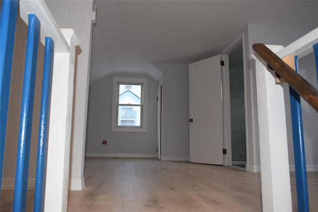 additional living space with lofted ceiling, light wood-style flooring, and baseboards