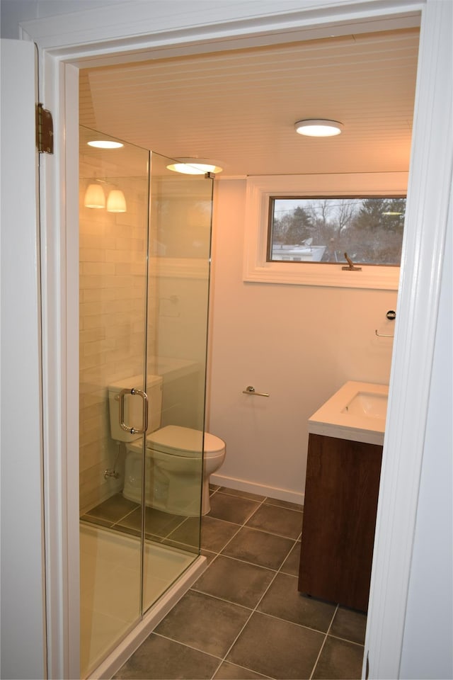 bathroom with a stall shower, baseboards, toilet, tile patterned floors, and vanity