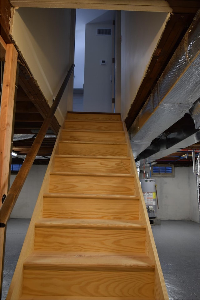 staircase with visible vents and gas water heater