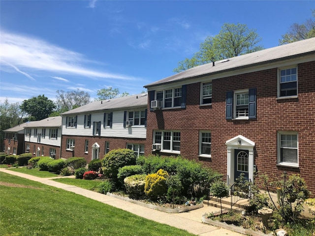 view of front of house featuring cooling unit and a front lawn