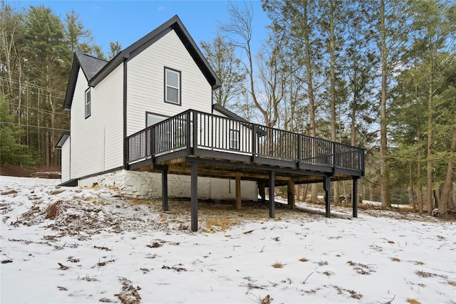 snow covered rear of property featuring a deck