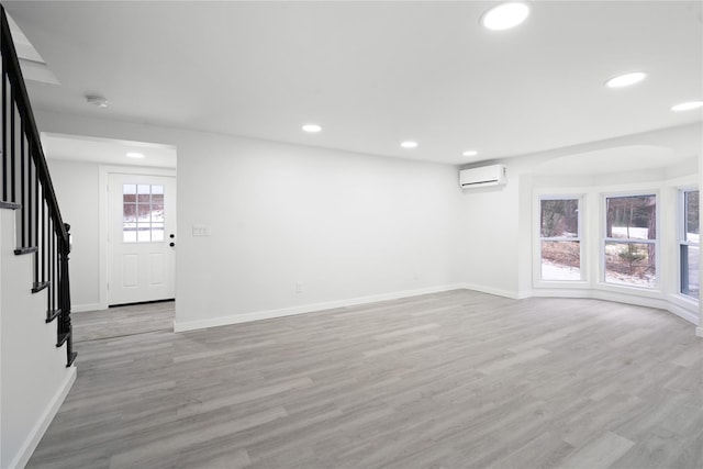 unfurnished room with light hardwood / wood-style flooring and a wall mounted AC