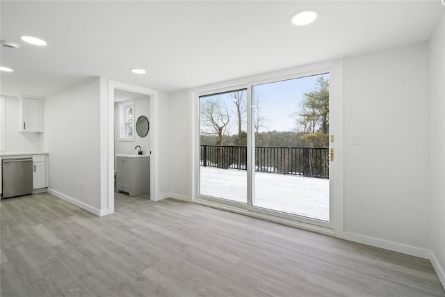 unfurnished living room with sink and light hardwood / wood-style flooring