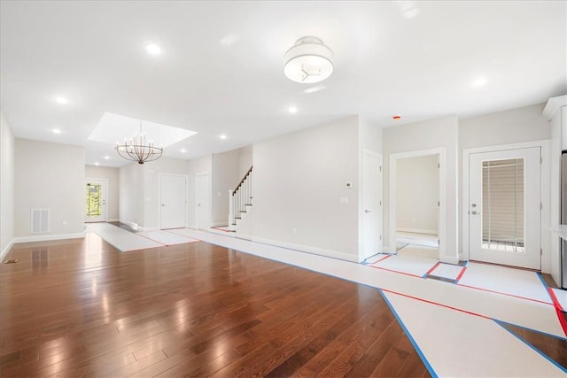 unfurnished living room featuring light hardwood / wood-style floors and an inviting chandelier