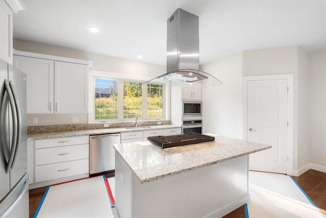 kitchen featuring island exhaust hood, light stone countertops, stainless steel appliances, white cabinets, and a center island