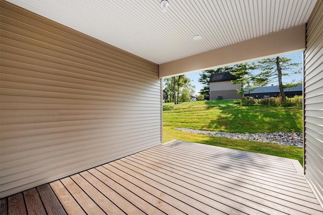 wooden terrace featuring a lawn