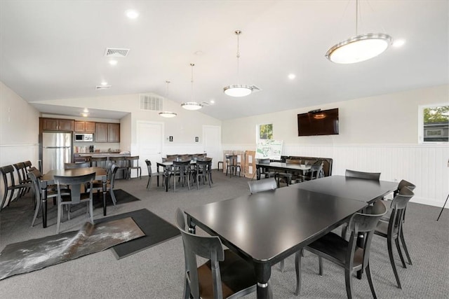 carpeted dining area with a wealth of natural light and vaulted ceiling