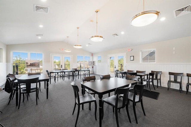 carpeted dining room featuring french doors, a wealth of natural light, and lofted ceiling