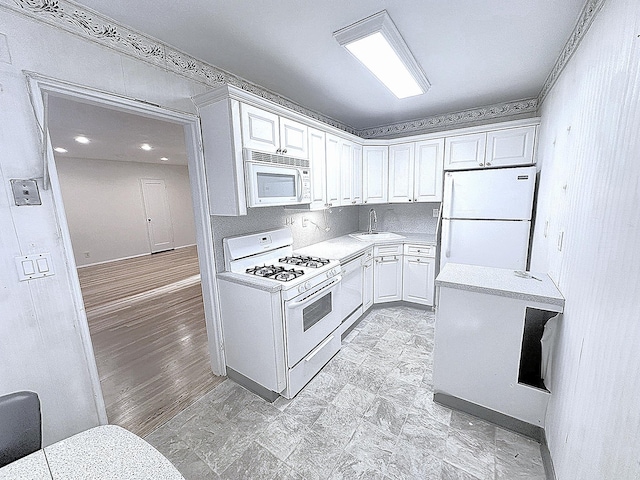 kitchen featuring white cabinets, white appliances, and sink