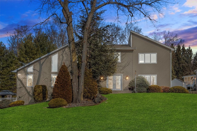 exterior space featuring french doors, a front yard, and stucco siding