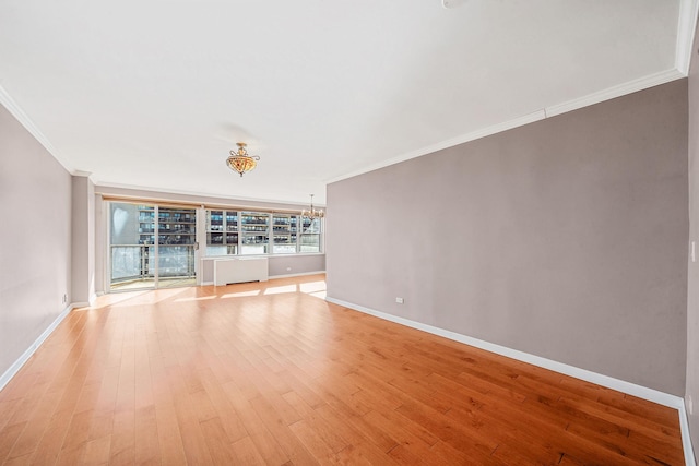 unfurnished room with a notable chandelier, crown molding, and light hardwood / wood-style flooring