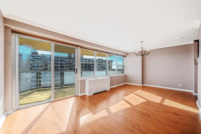 unfurnished room featuring crown molding, light hardwood / wood-style flooring, a water view, and a notable chandelier