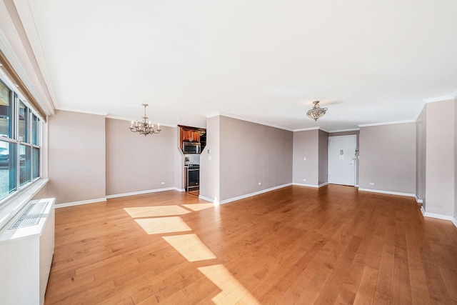 unfurnished living room with light hardwood / wood-style floors, an AC wall unit, crown molding, and an inviting chandelier