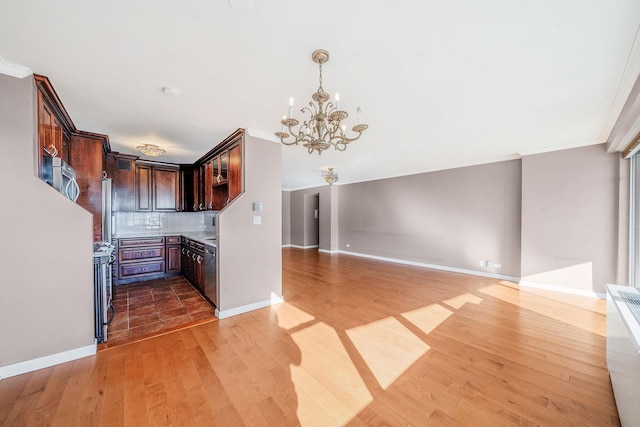 kitchen featuring a notable chandelier, ornamental molding, and tasteful backsplash