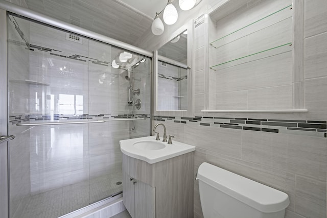 bathroom featuring vanity, toilet, tile walls, and walk in shower