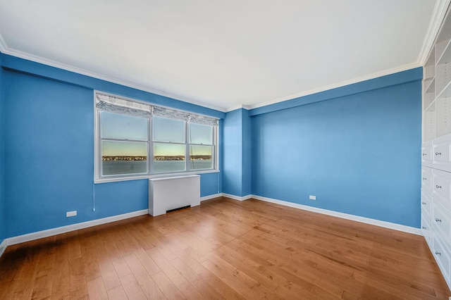 unfurnished room with radiator heating unit, light hardwood / wood-style floors, and crown molding