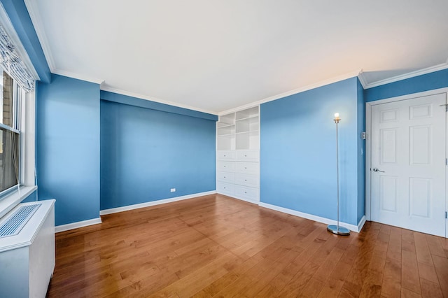 empty room with wood-type flooring and ornamental molding