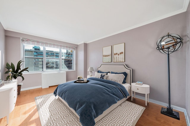 bedroom with crown molding, radiator heating unit, and hardwood / wood-style flooring