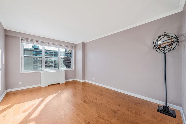 empty room with radiator, wood-type flooring, and ornamental molding