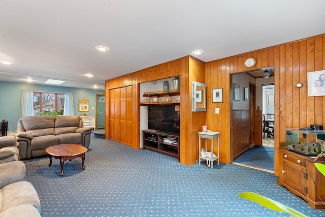 living room with wooden walls and dark carpet