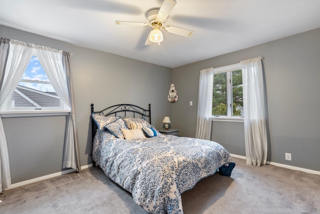 carpeted bedroom featuring ceiling fan and multiple windows