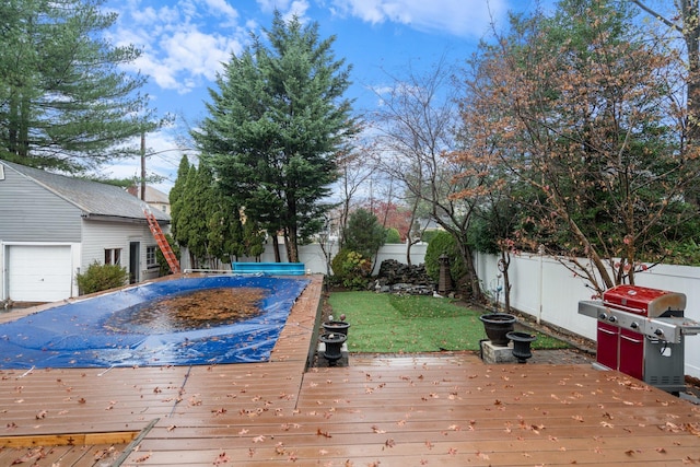 wooden deck featuring a yard, grilling area, and a covered pool