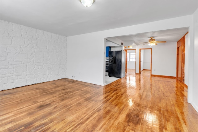 unfurnished living room with ceiling fan and light hardwood / wood-style flooring