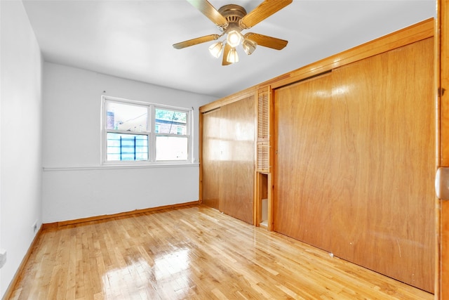 unfurnished bedroom featuring ceiling fan, light hardwood / wood-style floors, and a closet