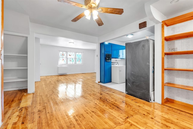 unfurnished living room featuring ceiling fan, light wood-type flooring, and washer / clothes dryer