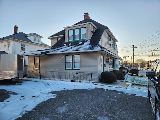 view of front facade with a chimney and a porch