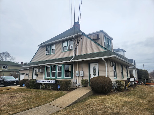 view of front of property featuring a front lawn, cooling unit, a garage, and a chimney