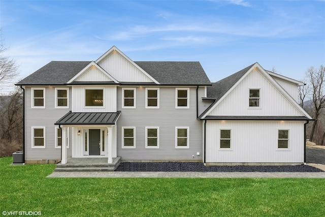 modern farmhouse style home with a front lawn and central AC unit