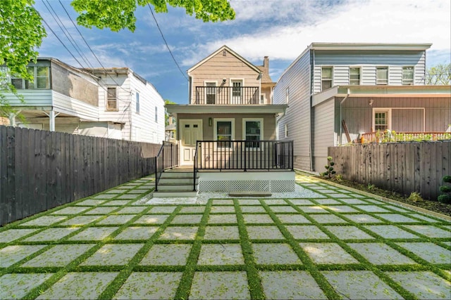 rear view of property featuring a yard and a balcony