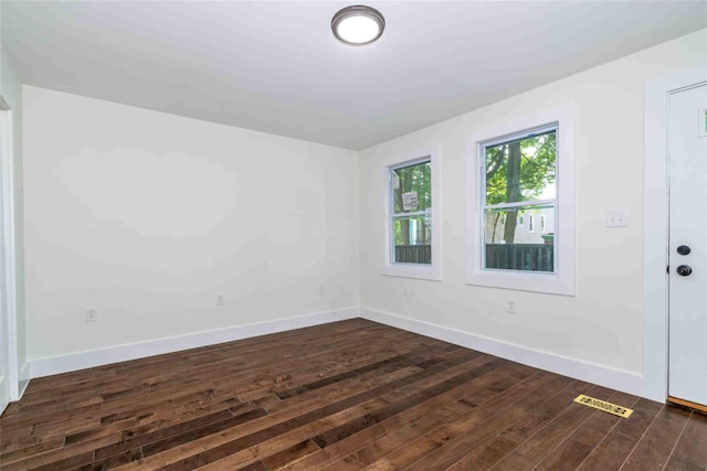 unfurnished room with dark wood-type flooring