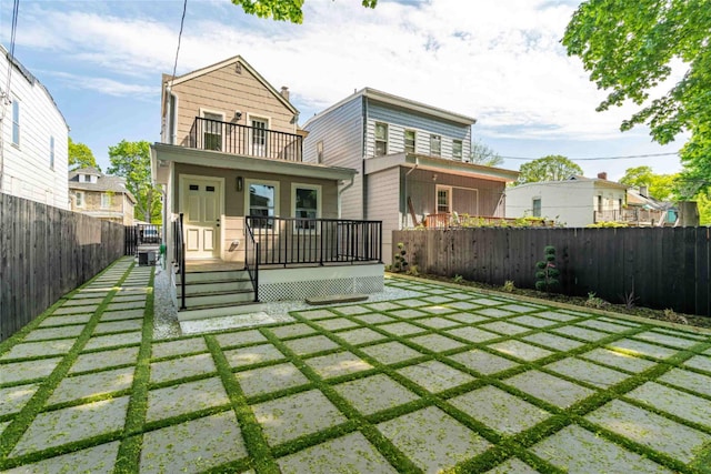 back of property with a porch and a balcony