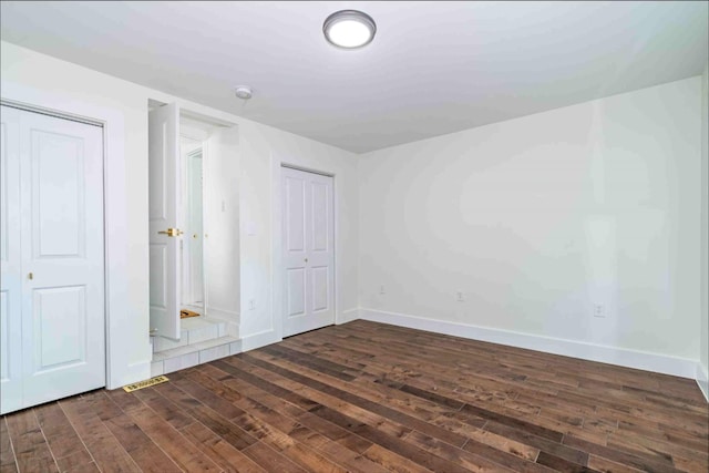 unfurnished bedroom featuring dark hardwood / wood-style floors