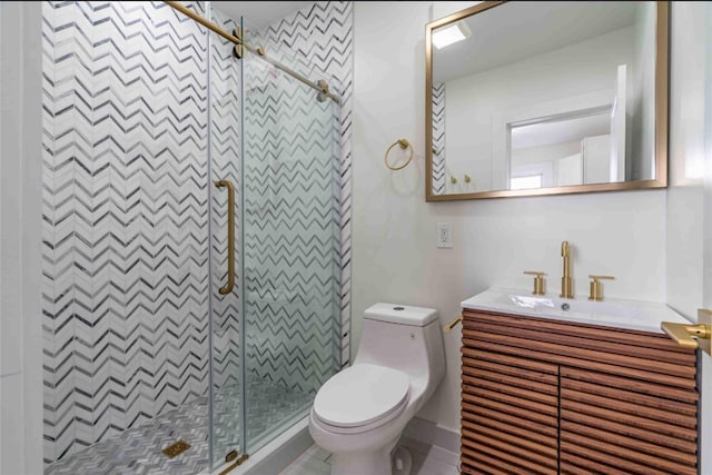 bathroom featuring toilet, vanity, and a shower with shower door