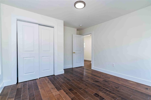 unfurnished bedroom featuring a closet and dark hardwood / wood-style floors