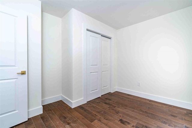 unfurnished bedroom featuring a closet and dark hardwood / wood-style floors