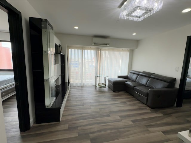 living room with a chandelier, dark hardwood / wood-style floors, and a wall mounted air conditioner