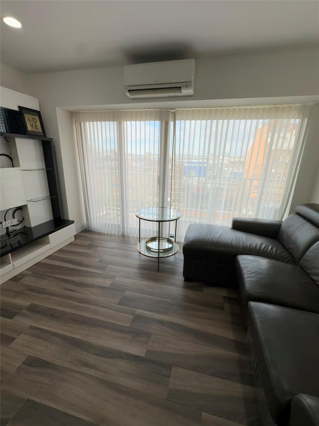 living room with a wall unit AC and dark hardwood / wood-style floors