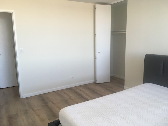 bedroom with a closet and hardwood / wood-style flooring