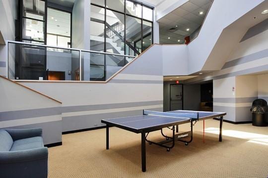 playroom featuring light colored carpet and a towering ceiling