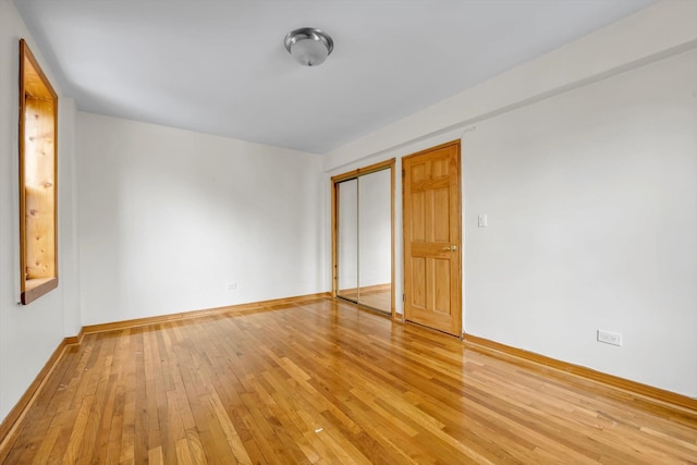 empty room with baseboards and wood finished floors