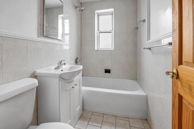 bathroom with tile walls, vanity, toilet, and tile patterned floors