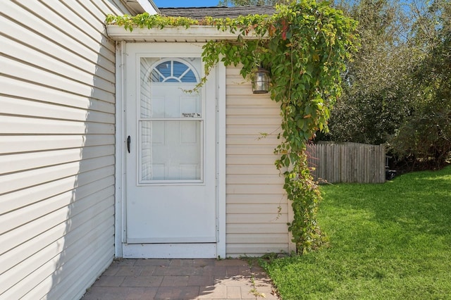 view of exterior entry with a lawn