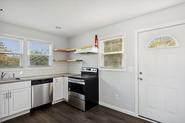 kitchen with backsplash, stainless steel appliances, sink, white cabinets, and dark hardwood / wood-style floors