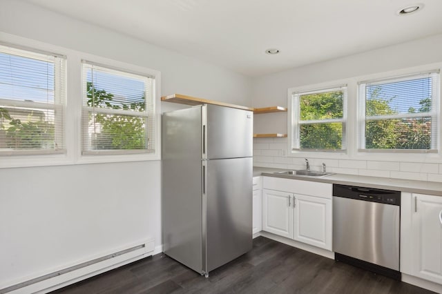 kitchen featuring sink, stainless steel appliances, baseboard heating, decorative backsplash, and white cabinets