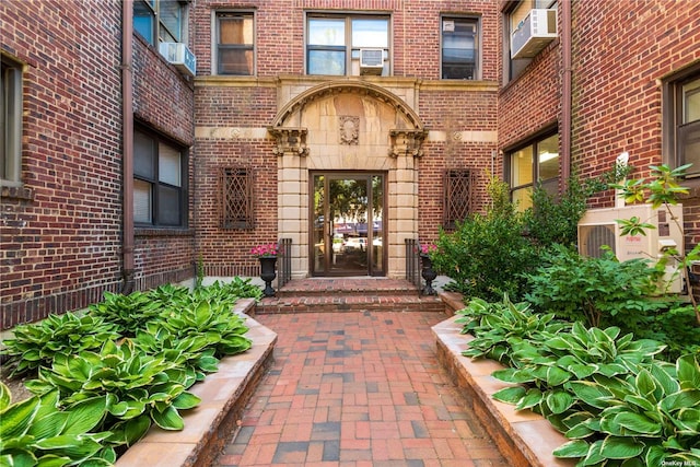 view of exterior entry featuring a wall mounted air conditioner