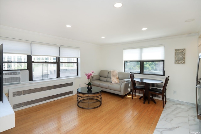 living room featuring a wealth of natural light, radiator heating unit, hardwood / wood-style flooring, and ornamental molding